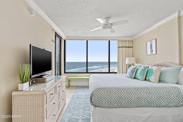 bedroom with light tile patterned floors, a textured ceiling, a ceiling fan, and crown molding