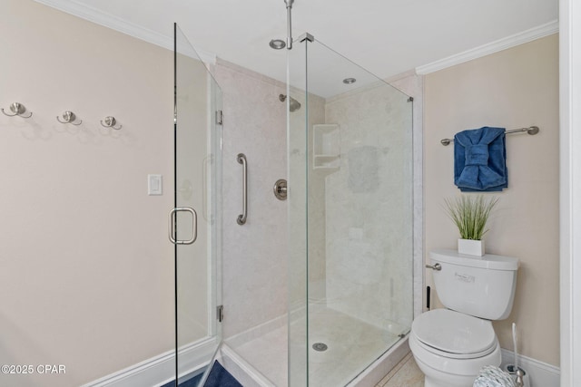 bathroom with baseboards, a shower stall, toilet, and crown molding