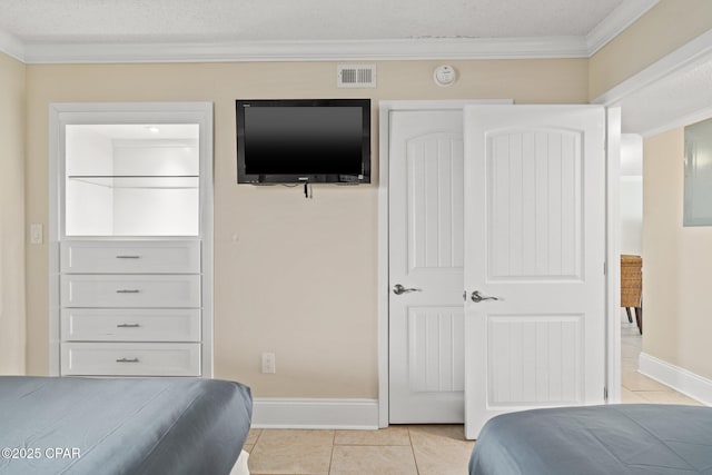 bedroom with crown molding, light tile patterned floors, visible vents, a textured ceiling, and baseboards