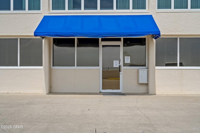 property entrance with stucco siding