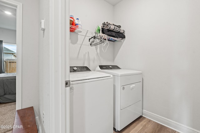 clothes washing area with light wood-type flooring and washer and dryer