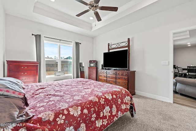 carpeted bedroom featuring crown molding, a tray ceiling, and ceiling fan