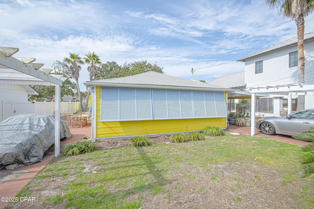 view of side of home featuring a yard, a patio area, and a pergola