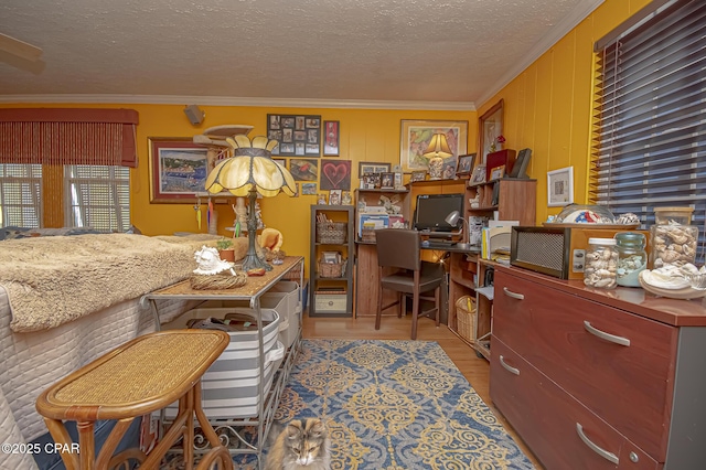 office with crown molding, light hardwood / wood-style floors, and a textured ceiling