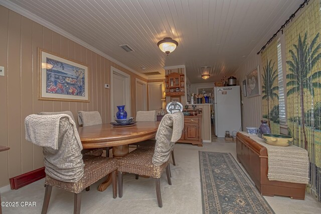 dining space with crown molding and wooden ceiling