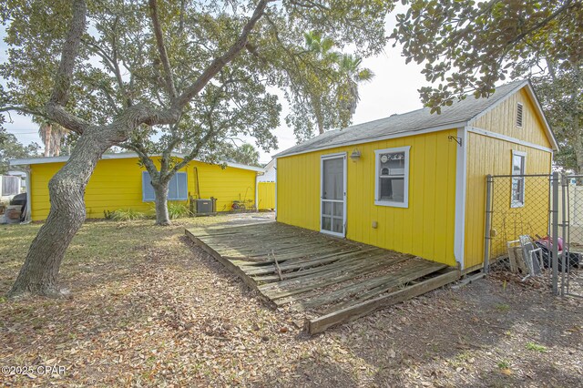 rear view of property featuring a wooden deck and central AC unit