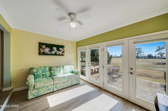 interior space with wood-type flooring, ceiling fan, crown molding, a rural view, and french doors