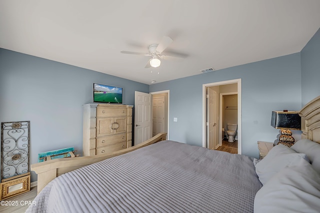 bedroom with wood-type flooring, ceiling fan, and ensuite bathroom