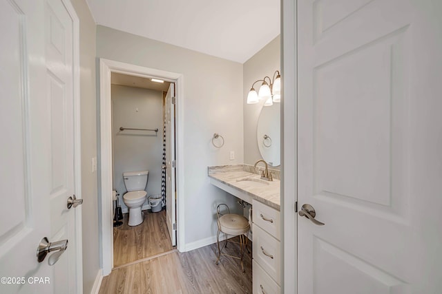 bathroom featuring vanity, hardwood / wood-style floors, and toilet