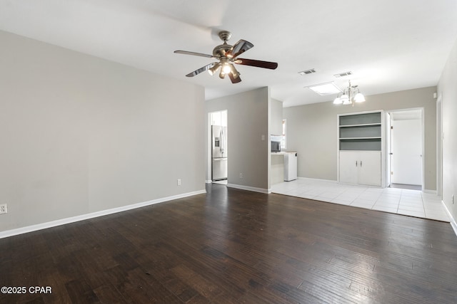 unfurnished living room featuring ceiling fan with notable chandelier and light wood-type flooring