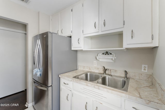 kitchen featuring white cabinetry, sink, and stainless steel fridge with ice dispenser