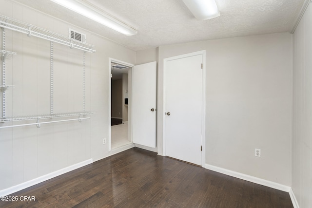 interior space featuring dark hardwood / wood-style flooring, a closet, and a textured ceiling