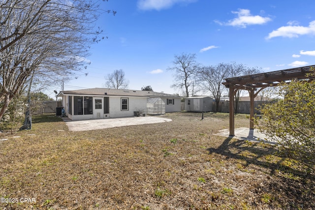 back of house with a patio, a yard, a pergola, a sunroom, and central AC