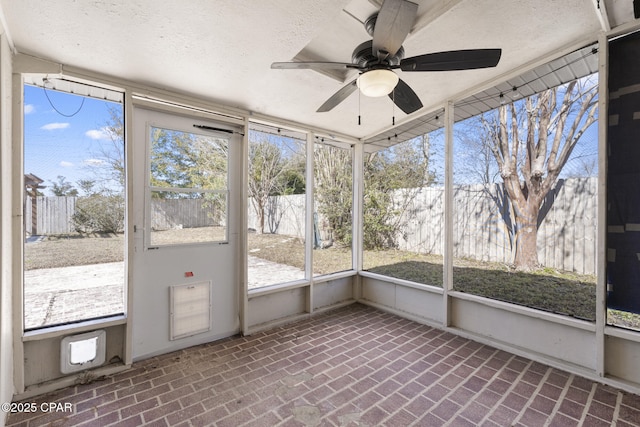 unfurnished sunroom with ceiling fan