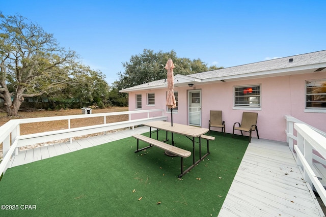 back of property with a wooden deck and a yard