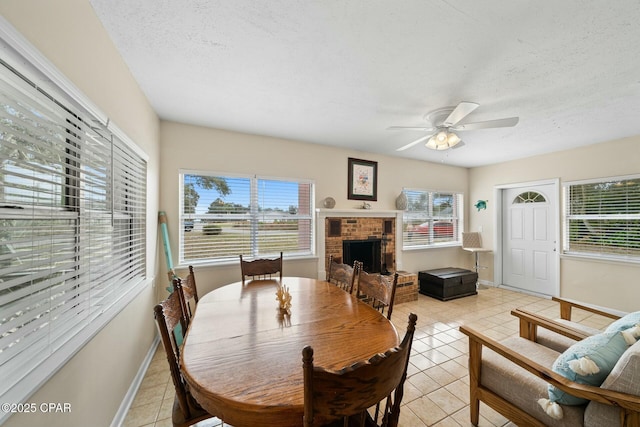 dining room featuring light tile patterned flooring, a wealth of natural light, and a fireplace