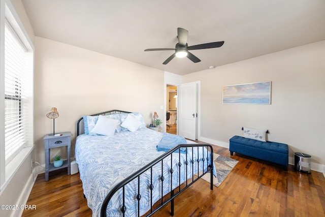 bedroom with multiple windows, dark wood-type flooring, and ceiling fan