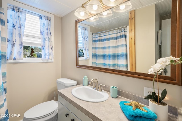 bathroom with vanity, toilet, and curtained shower