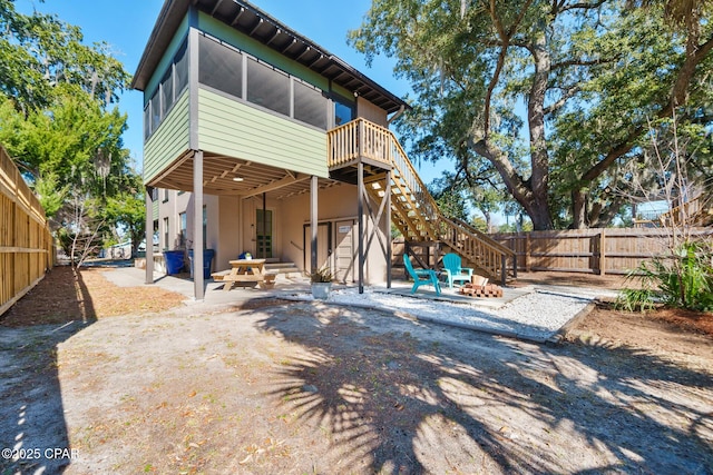 rear view of property featuring a sunroom and a patio