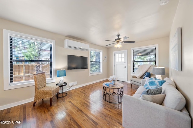 living room with wood-type flooring, an AC wall unit, and ceiling fan