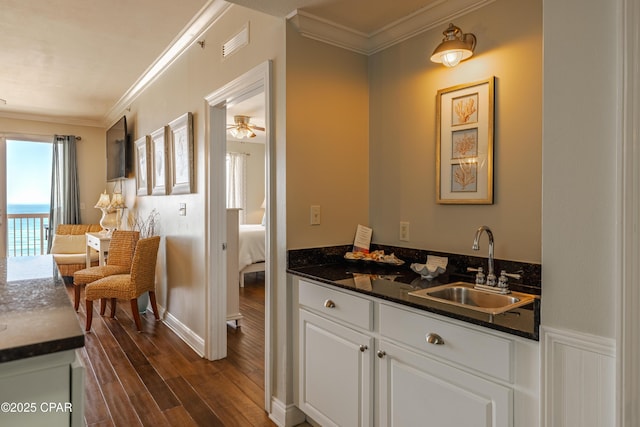 interior space with ornamental molding, vanity, and wood finished floors