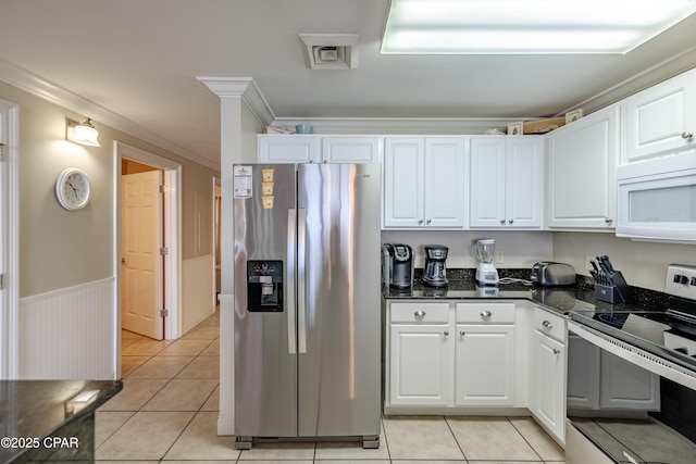 kitchen with a wainscoted wall, white cabinetry, appliances with stainless steel finishes, and crown molding