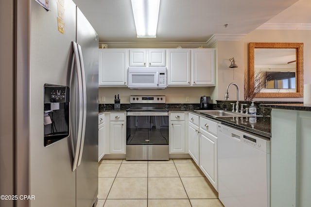 kitchen with stainless steel appliances, ornamental molding, light tile patterned flooring, a sink, and white cabinetry