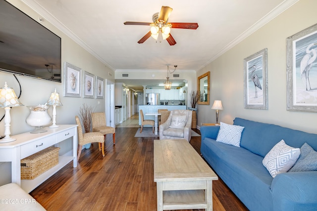 living room with dark wood-style floors, ornamental molding, and a ceiling fan