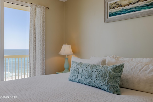 bedroom featuring a water view and multiple windows