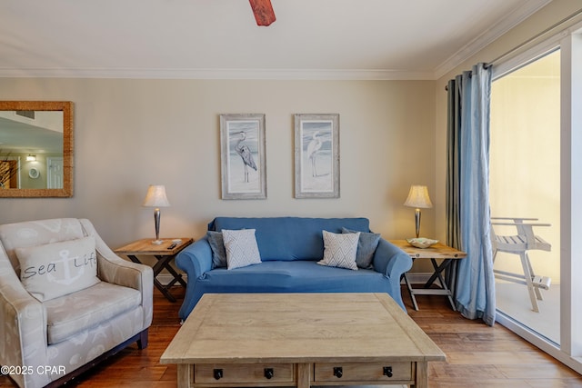 living area featuring ornamental molding and wood finished floors