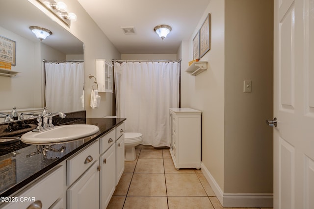 bathroom featuring baseboards, visible vents, toilet, tile patterned floors, and vanity