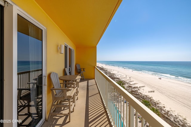 balcony featuring a view of the beach and a water view