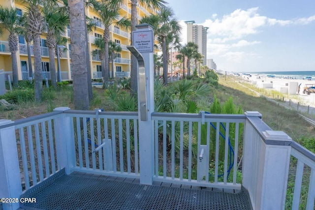 balcony featuring a water view and a beach view