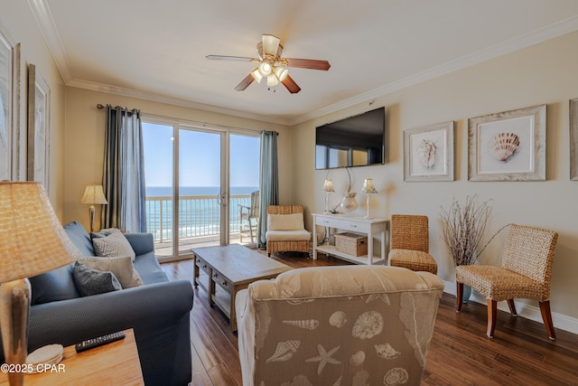 living area featuring ornamental molding, dark wood finished floors, baseboards, and a ceiling fan