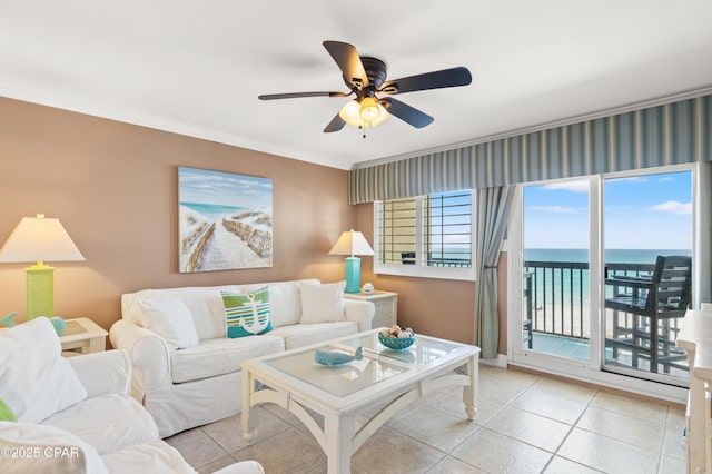 living room with crown molding, a water view, light tile patterned flooring, and ceiling fan