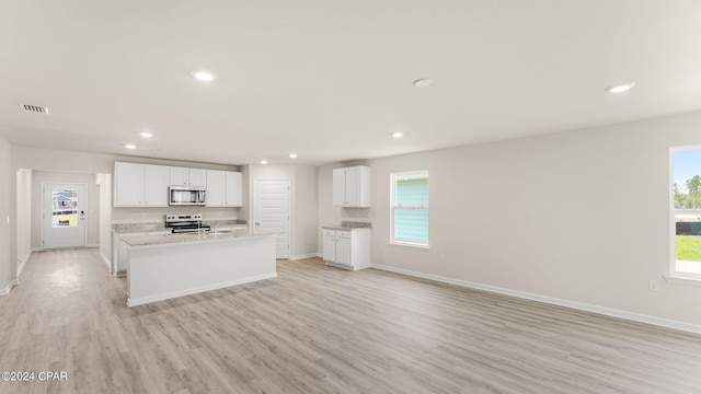 kitchen featuring visible vents, an island with sink, recessed lighting, stainless steel appliances, and light wood-style floors