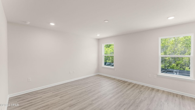 empty room featuring recessed lighting, baseboards, and light wood-style flooring