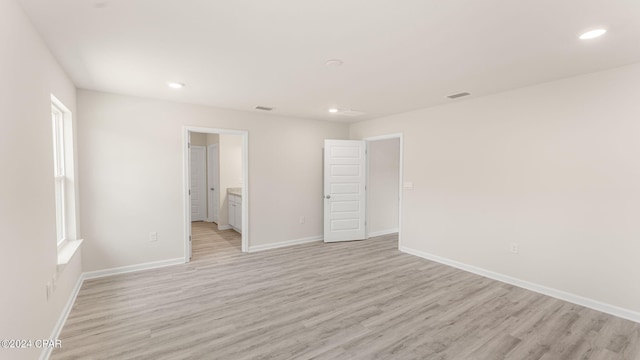 unfurnished room with visible vents, light wood-style flooring, recessed lighting, and baseboards