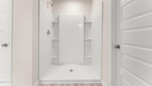 bathroom featuring baseboards and a stall shower