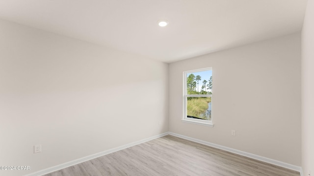 empty room with baseboards and light wood-type flooring