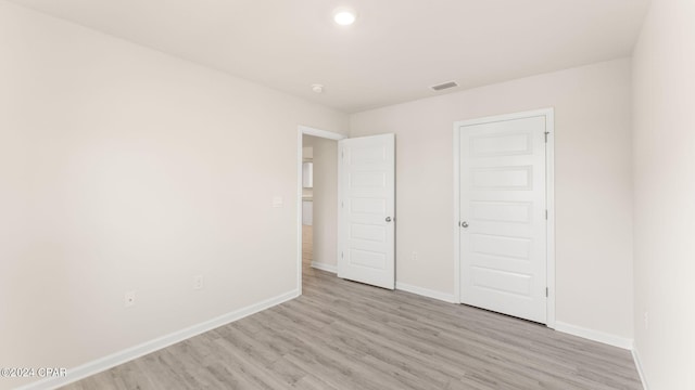 unfurnished bedroom featuring visible vents, baseboards, and light wood-style flooring