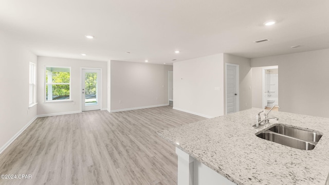 kitchen featuring light wood-type flooring, recessed lighting, visible vents, and a sink