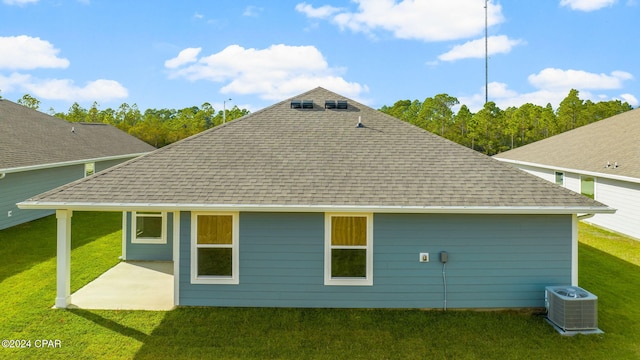 back of house featuring central air condition unit, a patio, a yard, and a shingled roof