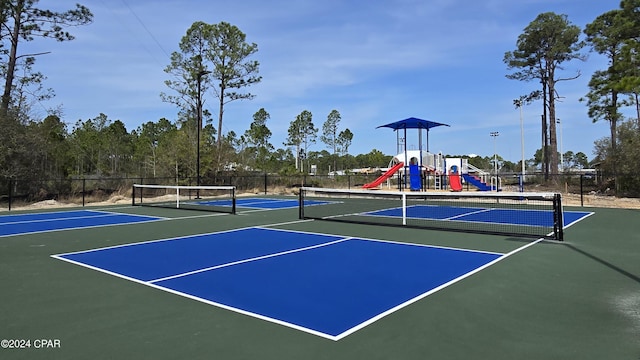 view of sport court featuring playground community, community basketball court, and fence