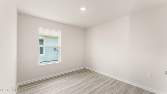 unfurnished room featuring baseboards and light wood-style flooring