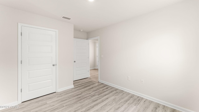 unfurnished bedroom with visible vents, light wood-type flooring, and baseboards