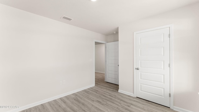 unfurnished bedroom with light wood-type flooring, visible vents, and baseboards