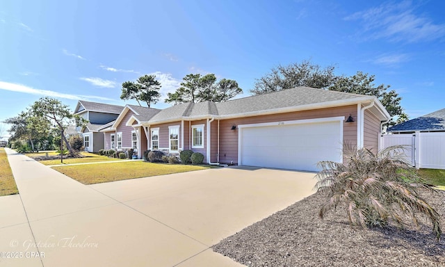 view of front of home featuring a front lawn, driveway, an attached garage, and fence