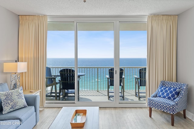 living room featuring a wealth of natural light, wood finished floors, and a water view