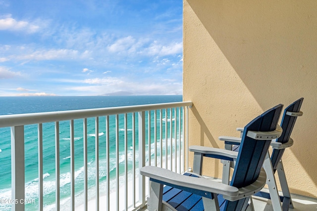 balcony featuring a beach view and a water view